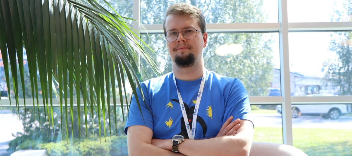 Puolikuva toimistoinsinööriharjoittelija Hugosta. Vasemmalla viherkasvi.