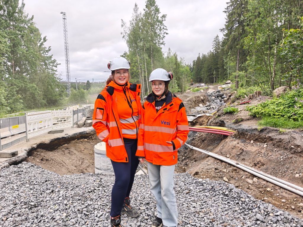 Puolikuva työnjohtoharjoittelijoista työmaan edessä