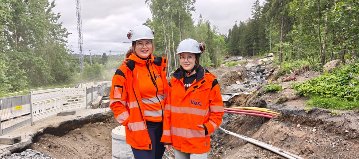 Työnjohtoharjoittelijat koko kuvassa työmaan edessä.