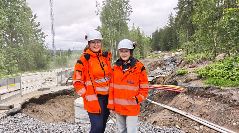 Työnjohtoharjoittelijat koko kuvassa työmaan edessä.